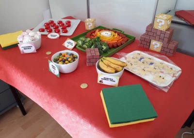 Table avec buffet d'anniversaire bonbons, fruits et fromages